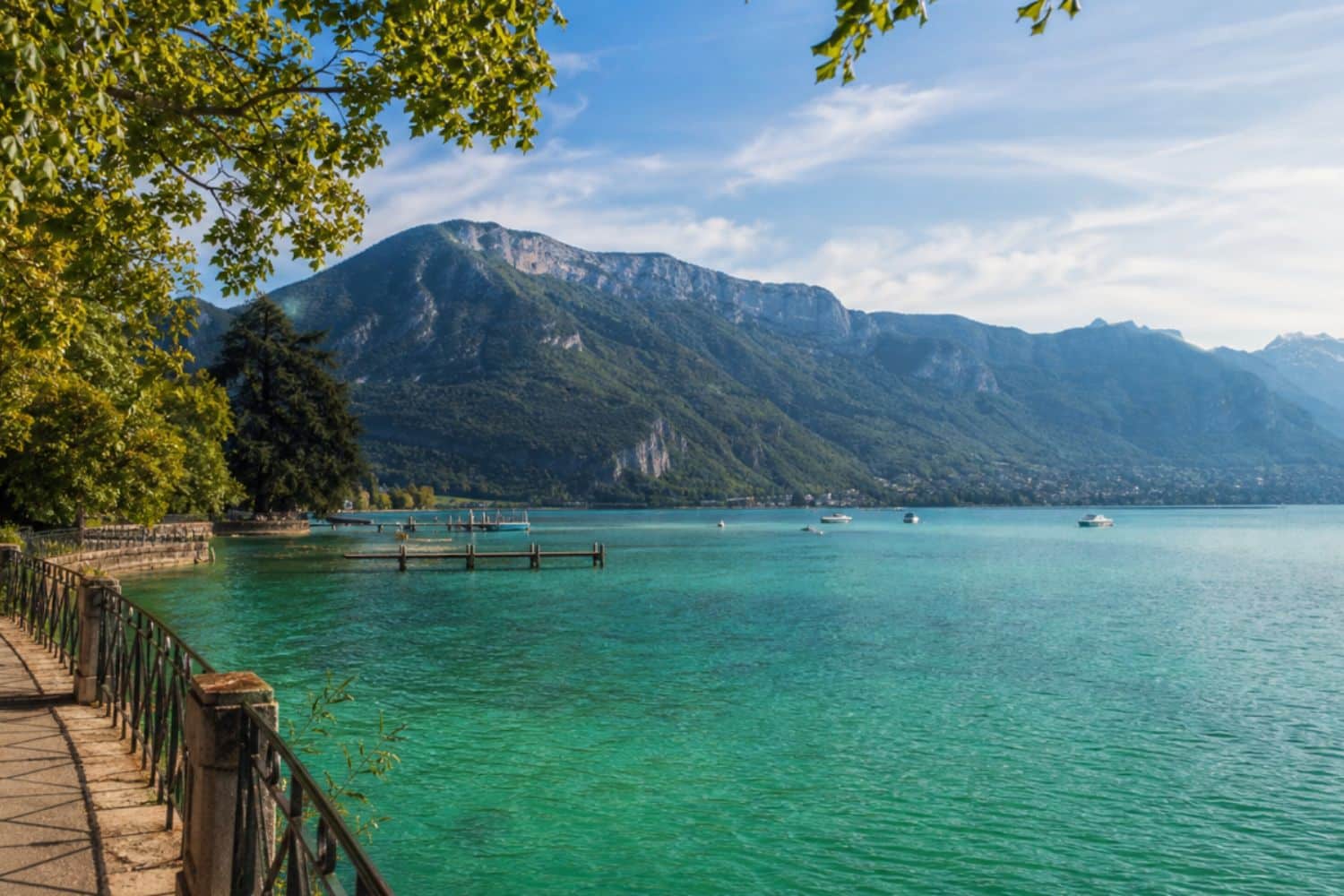 Lac turquoise bordé de montagnes et promenade